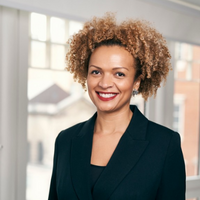 Person smiling in a professional setting with a window in the background.