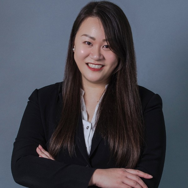 Person in business attire smiling with arms crossed
