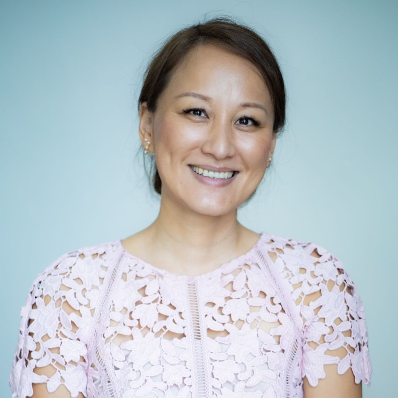 Person smiling in a light pink lace top.