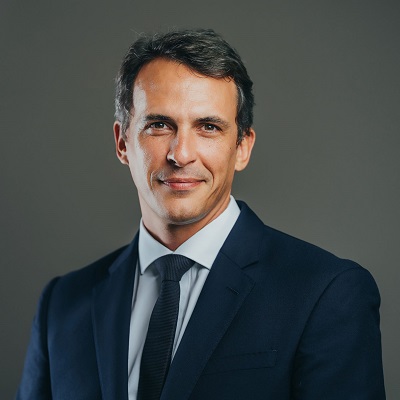 Person in a suit posing against a neutral background.