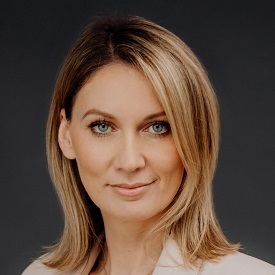 Person with short hair smiling in a professional portrait.