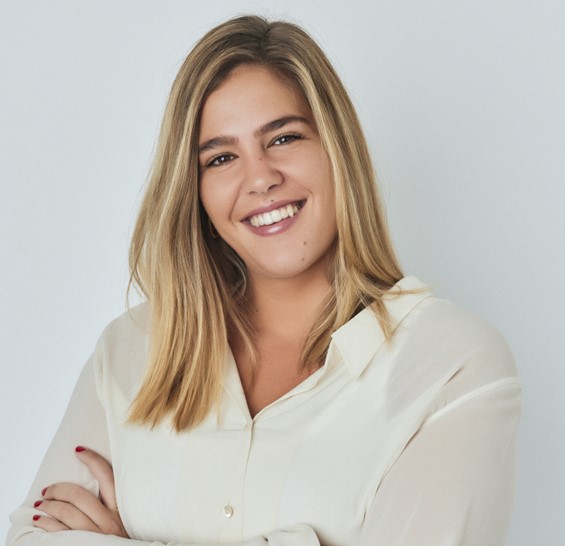 Person smiling in a white shirt against a light background.