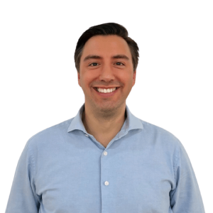 Person smiling in light blue shirt against white background.