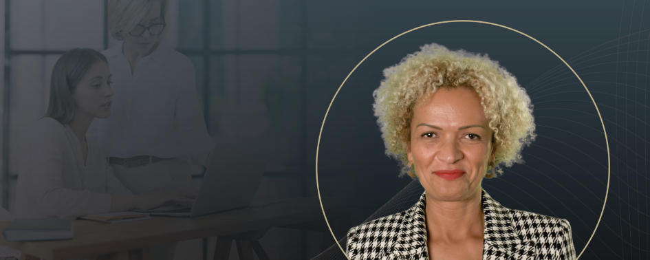 A professional portrait of a woman with curly blonde hair, wearing a patterned blazer, overlaid on a dark background with subtle graphic lines and the faint image of two women working on a laptop in the background.
