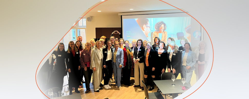 a group standing and smiling in a conference room
