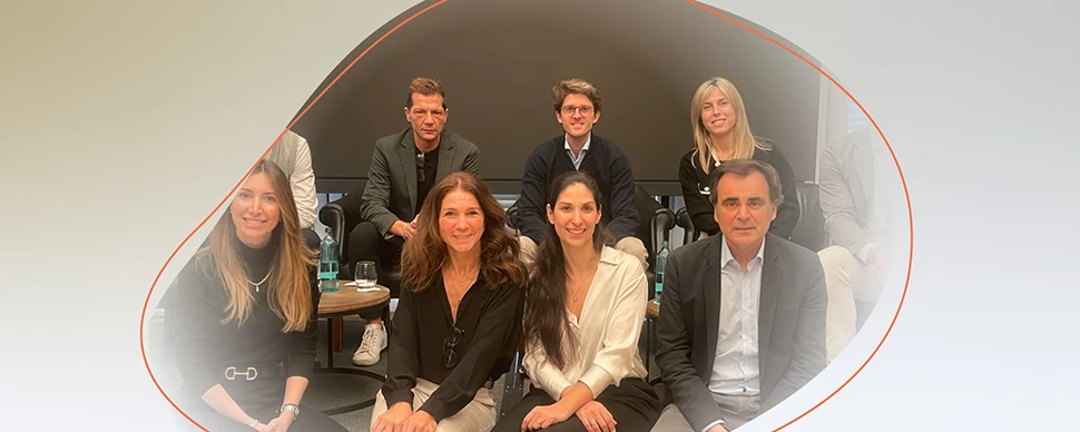 Group of people sitting and standing together in a meeting room.