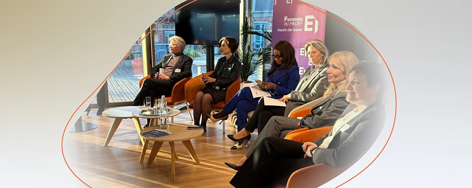 Panel discussion with professionals seated on stage during a corporate event.