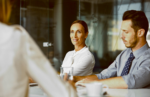 People sitting at a table in a meeting room.