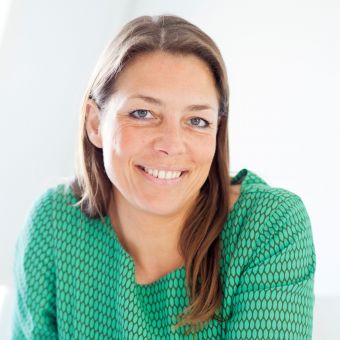 Person smiling while wearing a green patterned shirt.