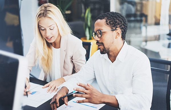 Two people discussing financial documents at a table.