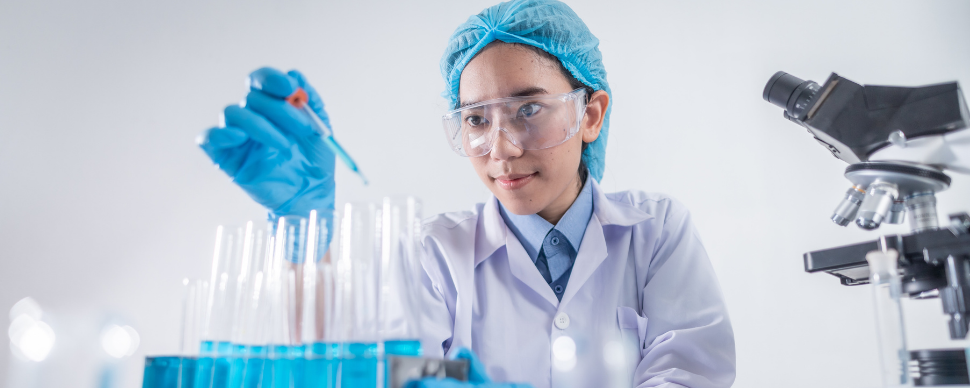 Scientist wearing protective gear working with test tubes in a laboratory.