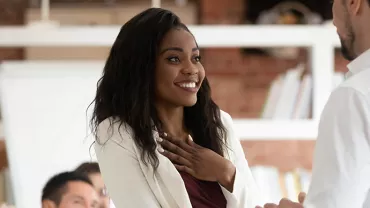 Person smiling and engaged in conversation in an office setting.