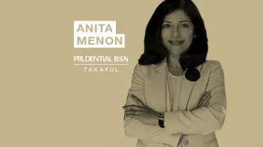 Person in a suit with arms crossed near the words Anita Menon Prudential BSN Takaful.