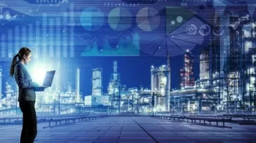 A person using a laptop with a digital data overlay and an industrial background.