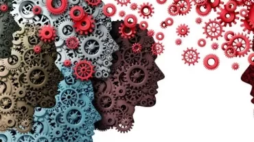 Silhouetted faces made of interconnected gears, symbolizing teamwork and communication.