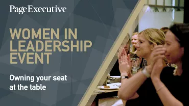 Conference attendees applauding, with 'Women in Leadership Event' on screen.