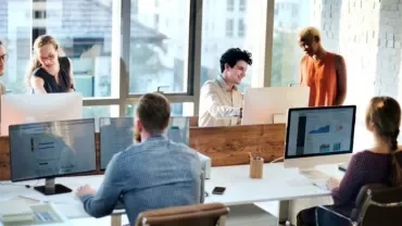 Team collaborating in a bright office with computers.