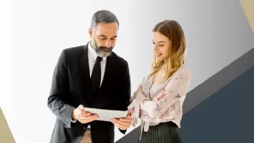 Two people reviewing information on a tablet.