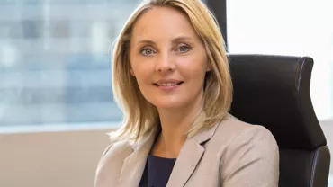 Person smiling while sitting in an office chair.