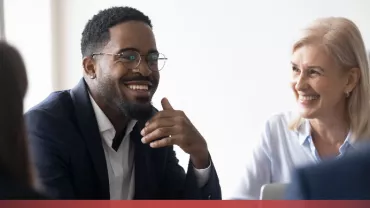 Colleagues smiling in a meeting.