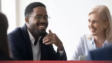 Group of people happily discussing in an office setting.