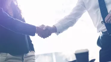 People shaking hands in a business setting.