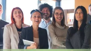 Group of smiling colleagues in an office setting.