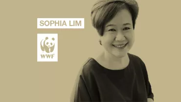 Person smiling in front of a beige background with WWF logo.