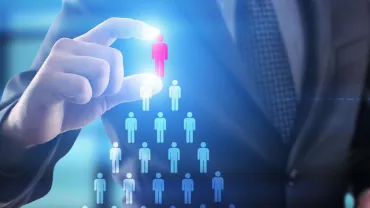 Businessperson selecting a red figure among blue figures, symbolizing decision-making or leadership.
