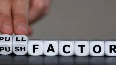 Hand flipping cube between 'push' and 'pull' factor concept.