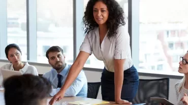 Person leads a meeting in a modern office setting.