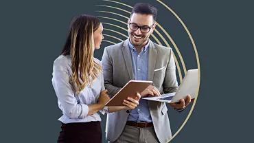 Two people discussing work, one holding a tablet, the other a laptop, against a dark background with golden arcs.