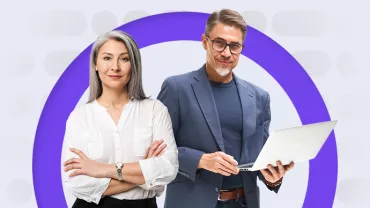 Two professionals stand confidently with a laptop.