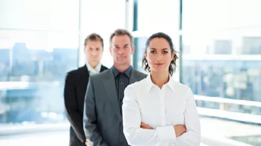 Business professionals standing in a modern office setting.