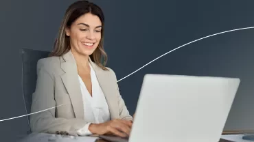 a woman smiling looking at her computer