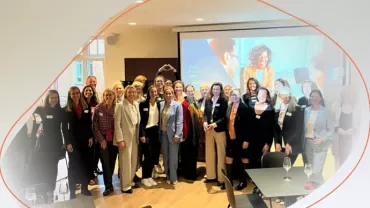 a group standing and smiling in a conference room