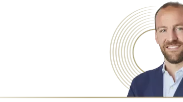 a man smiling with a circle shape in the background