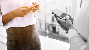 Two people using smartphones indoors