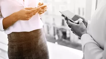 Two people using smartphones indoors