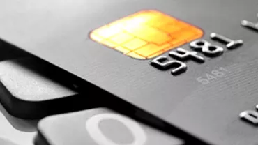 Close-up of a black credit card with an EMV chip.