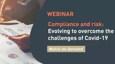 Two hands reviewing charts during a webinar on compliance and risk related to Covid-19.