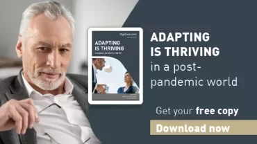 Smiling person seated near an eBook cover titled 'Adapting is Thriving'.