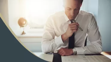 Person in formal attire reviewing documents at a desk.