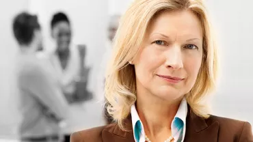 Person smiling with blurred group in the background.