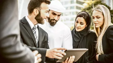 Group of people discussing something on a tablet outside in an urban setting.