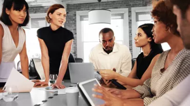 A diverse group of people having a meeting around a table.