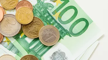 Euro coins and banknotes on a surface.