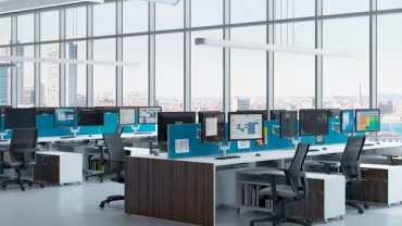 Modern office with large windows and rows of desks with computers.