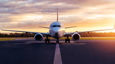 Airplane on runway during sunset, facing forward.