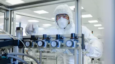 Person in protective suit working in a laboratory.